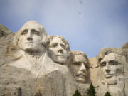 Visitors take in the massive sculpture carved into Mount Rushmore at the Mount Rushmore National Memorial on Sept. 21 in, Keystone, S.D. Fewer planes and helicopters will be flying tourists over Mount Rushmore and other national monuments and parks as new regulations take effect that are intended to protect the serenity of some of the nation&rsquo;s most beloved natural areas.