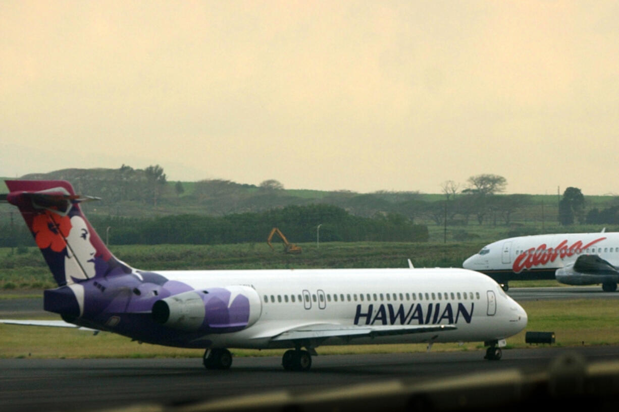 FILE - An Hawaiian Airlines plane taxis for position at Kahalui, Hawaii, on the island of Maui, March 24, 2005. Alaska Air Group said Sunday, Dec. 3, 2023, that it agreed to buy Hawaiian Airlines in a $1 billion deal.