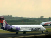 FILE - An Hawaiian Airlines plane taxis for position at Kahalui, Hawaii, on the island of Maui, March 24, 2005. Alaska Air Group said Sunday, Dec. 3, 2023, that it agreed to buy Hawaiian Airlines in a $1 billion deal.