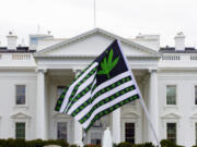 FILE - A demonstrator waves a flag with marijuana leaves depicted on it during a protest calling for the legalization of marijuana, outside of the White House on April 2, 2016, in Washington.  President Joe Biden is pardoning thousands of people who were convicted of use and simple possession of marijuana on federal lands and in the District of Columbia. The White House says his action Friday is his latest round of executive clemencies meant to rectify racial disparities in the justice system.