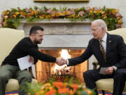 President Joe Biden shakes hands with Ukrainian President Volodymyr Zelenskyy as they meet in the Oval Office of the White House, Tuesday, Dec. 12, 2023, in Washington.