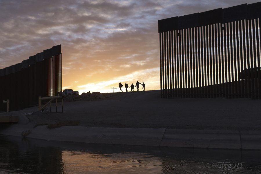 FILE - A pair of migrant families from Brazil passes through a gap in the border wall to reach the United States after crossing from Mexico in Yuma, Ariz., to seek asylum on June 10, 2021. A federal judge was poised Friday, Dec.8, 2023, to prohibit separation of families at the border for purposes of deterring immigration for eight years.