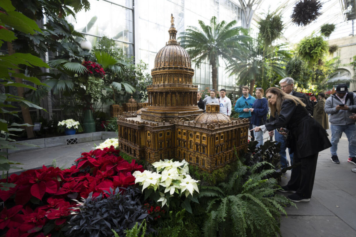 Visitors look at a replica of the U.S. Capitol adorned with different varieties of poinsettias on display Dec. 16 at the U.S. Botanic Garden in Washington.