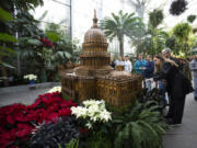 Visitors look at a replica of the U.S. Capitol adorned with different varieties of poinsettias on display Dec. 16 at the U.S. Botanic Garden in Washington.