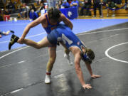 Nolan Carney of Ridgefield (left) wrestles Wyatt Ballard of La Center in the semifinals of the 150-pound division at the La Center Wildcat Invitational wrestling tournament at La Center High School on Saturday, Dec. 9, 2023.