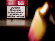 FILE - An Elf Bar disposable vaping pod device and a health warning on its packaging is displayed, Monday, June 26, 2023, in Washington. U.S. lawmakers are demanding information on federal efforts to stop the recent influx of kid-appealing electronic cigarettes from China. A letter sent Thursday, Dec.