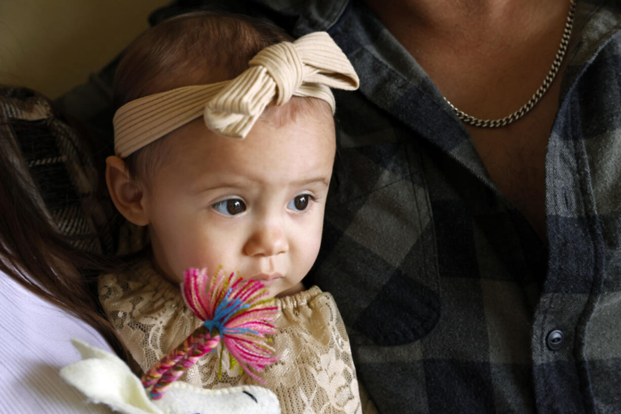 One-year-old Cora Dibert is held by her parents at The Bridge Church, Saturday, Dec. 2, 2023, in Mustang, Okla. No amount of lead exposure is safe for children and the effects on brain development can show up years later, says Dr. Jennifer Sample, a pediatric toxicologist who consults for industry and academics.