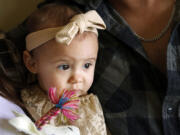 One-year-old Cora Dibert is held by her parents at The Bridge Church, Saturday, Dec. 2, 2023, in Mustang, Okla. No amount of lead exposure is safe for children and the effects on brain development can show up years later, says Dr. Jennifer Sample, a pediatric toxicologist who consults for industry and academics.