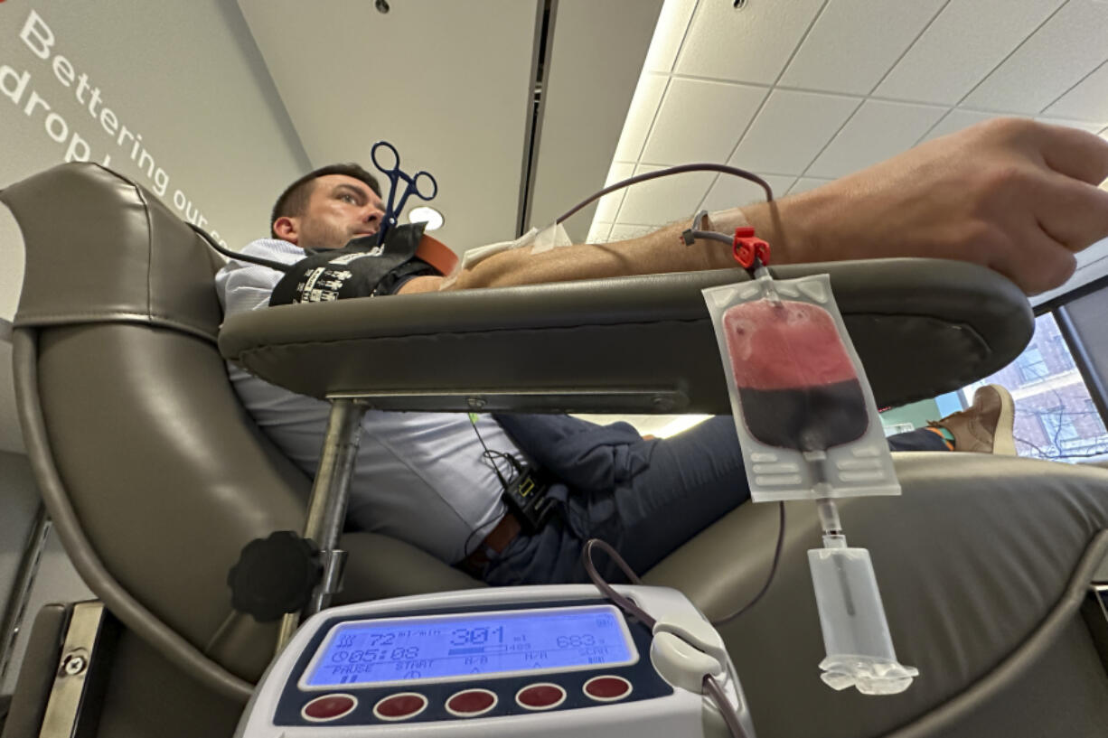 Aaron Posey, a Bloodworks Northwest executive, donates blood at the blood center&rsquo;s Seattle headquarters on Dec. 14, 2023. New federal guidelines that dropped an abstinence requirement before gay men in monogamous relationships can give blood are opening a new pool of potential donors. Posey, whose own life was saved by a transfusion when he fell down a set of stairs and broken glass sliced an artery, welcomed the new guidance, saying hospitals and patients need access to a new pool of donors.