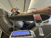 Aaron Posey, a Bloodworks Northwest executive, donates blood at the blood center&rsquo;s Seattle headquarters on Dec. 14, 2023. New federal guidelines that dropped an abstinence requirement before gay men in monogamous relationships can give blood are opening a new pool of potential donors. Posey, whose own life was saved by a transfusion when he fell down a set of stairs and broken glass sliced an artery, welcomed the new guidance, saying hospitals and patients need access to a new pool of donors.