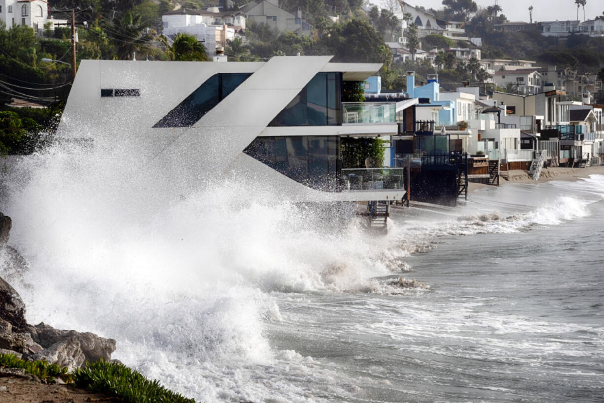 Waves smash against a home along the California coast in Malibu Beach, Calif. on Friday, Dec. 29, 2023. Powerful surf rolled onto beaches on the West Coast and Hawaii as a big swell generated by the stormy Pacific Ocean pushed toward shorelines, causing localized flooding.