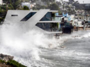 Waves smash against a home along the California coast in Malibu Beach, Calif. on Friday, Dec. 29, 2023. Powerful surf rolled onto beaches on the West Coast and Hawaii as a big swell generated by the stormy Pacific Ocean pushed toward shorelines, causing localized flooding.