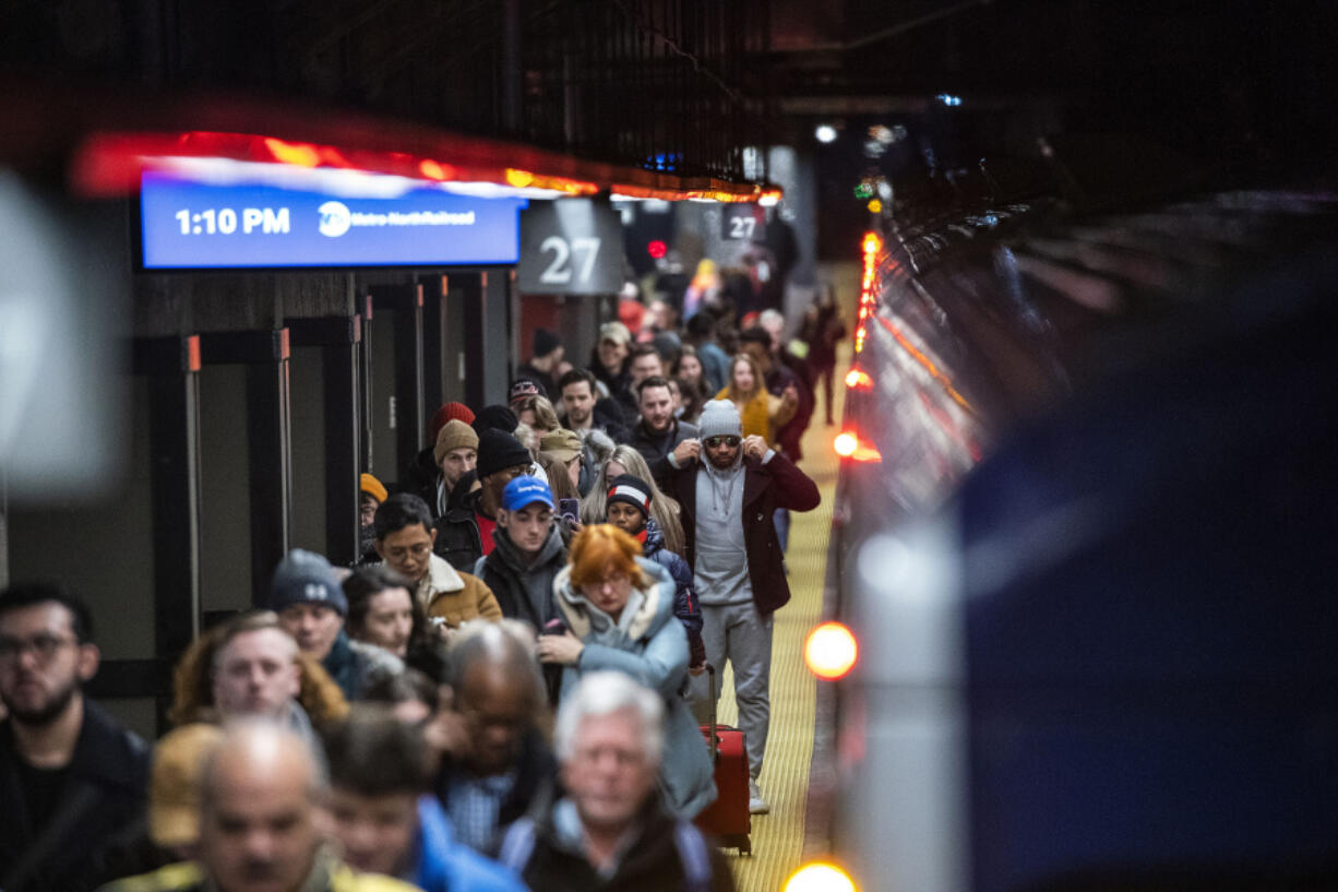 Travelers walk the ramp as they arrive to Grand Central Station in New York, Thursday, Dec. 21, 2023.