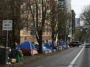 FILE - Tents line the sidewalk on SW Clay St in Portland, Ore., Dec. 9, 2020. According to an annual report released by regional officials Wednesday, Dec. 20, 2023, fentanyl and methamphetamine drove a record number of homeless deaths last year in Oregon&rsquo;s Multnomah County, home to Portland.