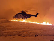 This image made from video provided by the Icelandic Coast Guard shows its helicopter flying near magma running on a hill near Grindavik on Iceland&rsquo;s Reykjanes Peninsula sometime around late Monday, Dec. 18, or early Tuesday, Dec. 19, 2023. A volcanic eruption started Monday night on Iceland&rsquo;s Reykjanes Peninsula, turning the sky orange and prompting the country&rsquo;s civil defense to be on high alert.