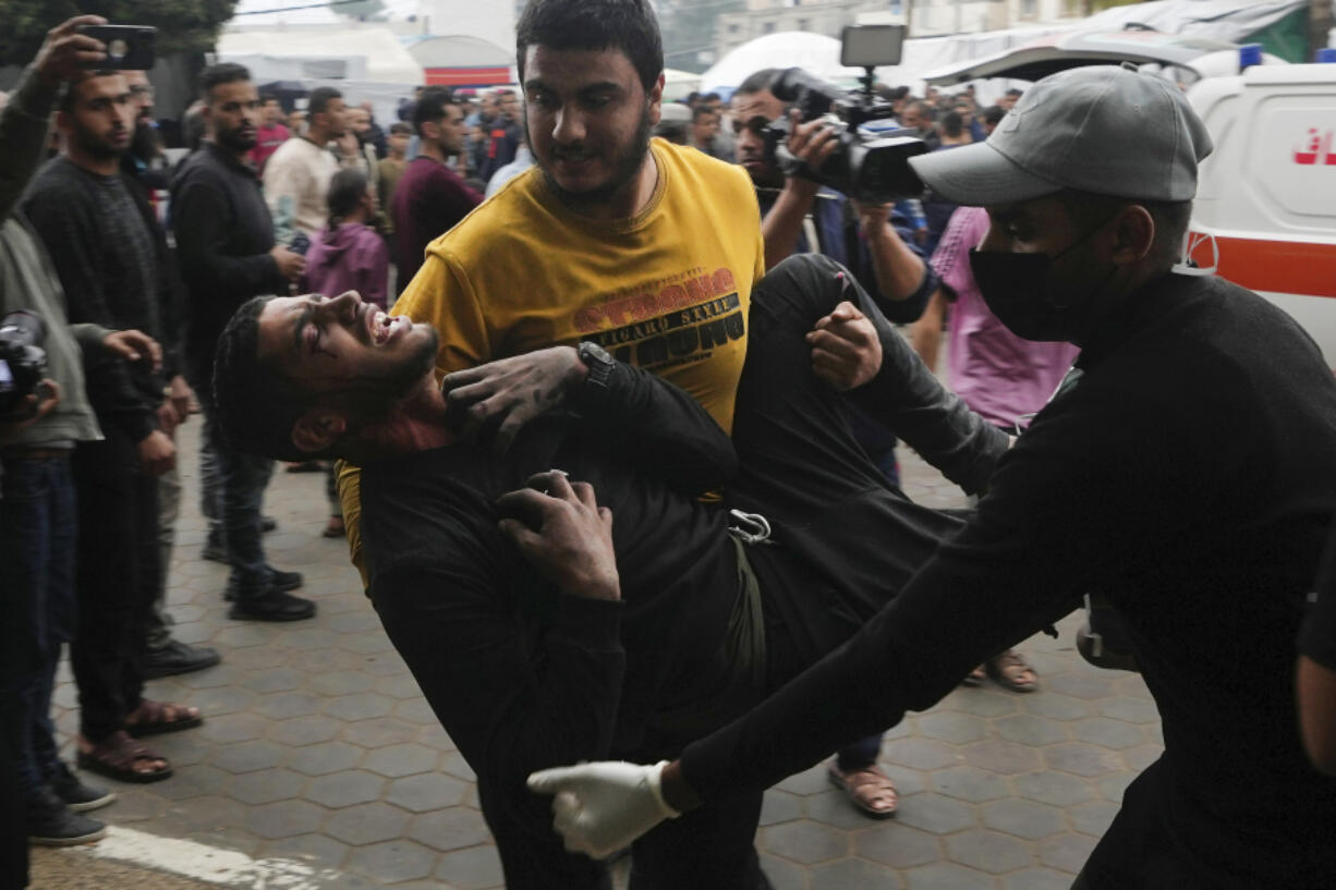 Palestinians wounded in the Israeli bombardment of the Gaza Strip are brought to the hospital in Deir al Balah on Tuesday, Dec. 5, 2023.