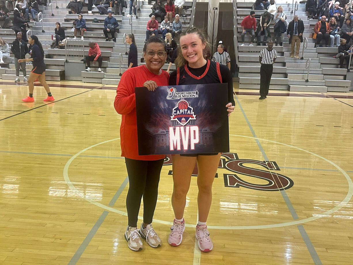 Camas junior Keirra Thompson poses with an official with the Capitol Invitational in Washington, D.C., after being named the game’s MVP after the Papermakers’ 51-45 win over Maret of Washington, D.C.