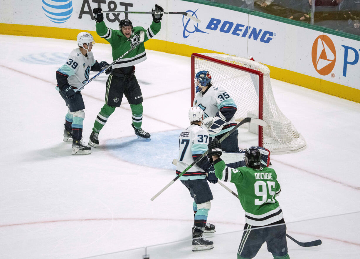 Dallas Stars defenseman Thomas Harley, top, celebrates after scoring the game-winning goal on an assist from center Matt Duchene (95) as Seattle Kraken goaltender Joey Daccord (35), defenseman Ryker Evans (39) and center Yanni Gourde (37) look on during overtime of an NHL hockey game Monday, Dec. 18, 2023, in Dallas.