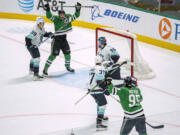 Dallas Stars defenseman Thomas Harley, top, celebrates after scoring the game-winning goal on an assist from center Matt Duchene (95) as Seattle Kraken goaltender Joey Daccord (35), defenseman Ryker Evans (39) and center Yanni Gourde (37) look on during overtime of an NHL hockey game Monday, Dec. 18, 2023, in Dallas.