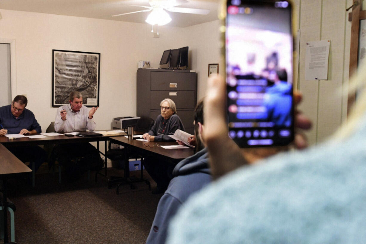 Cheryl Geidner of New Wilmington, Pa., records the Volant Borough Council meeting on her phone Tuesday, Dec. 12, 2023, at the borough building in Volant, Pa. Local governments in many states are making it harder for the public to access information, with residents increasingly complaining about issues like closed meetings and high fees for records, open government advocates and experts say. The result is important business often taking place under a shroud of secrecy.