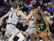 Gonzaga guards Dusty Stromer (4) and Nolan Hickman, center, double-team Mississippi Valley State guard Donovan Sanders (3) during the first half of an NCAA college basketball game, Monday, Dec. 11, 2023, in Spokane, Wash.