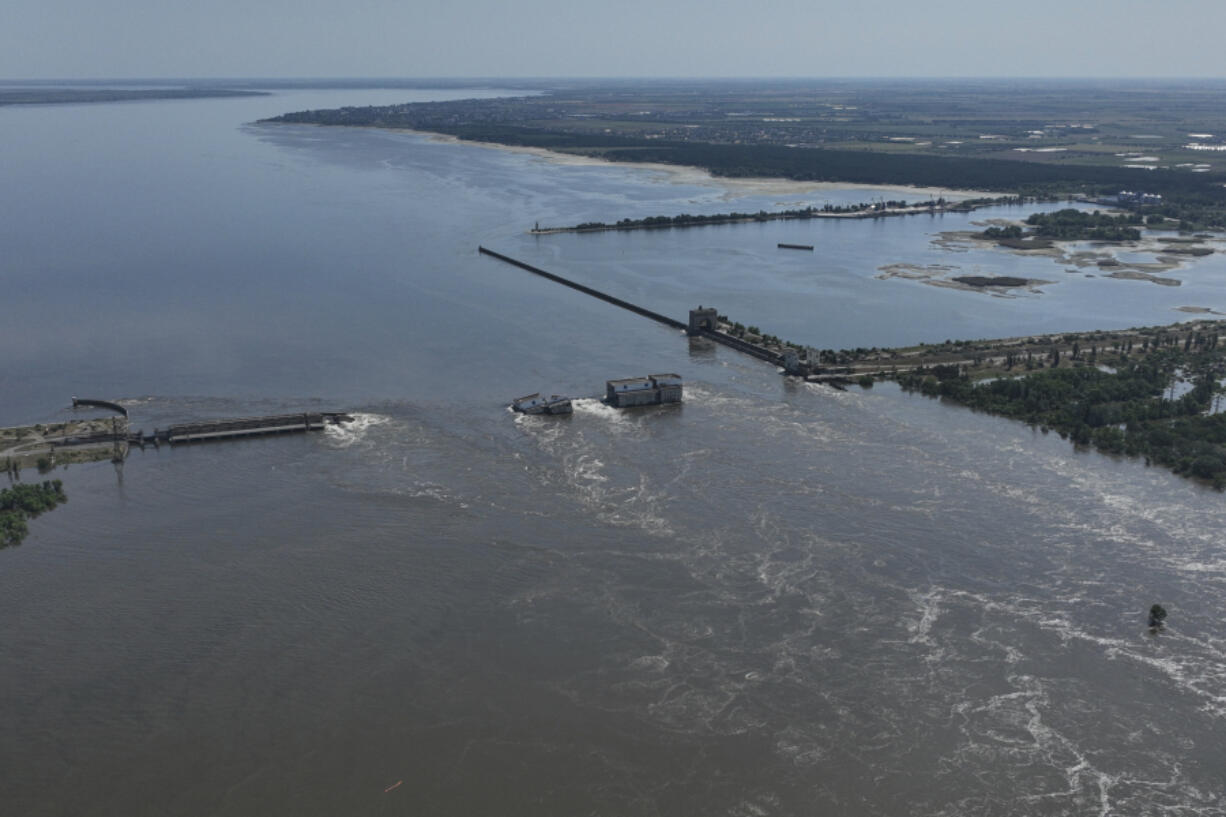 FILE - Water flows over the collapsed Kakhovka Dam in Nova Kakhovka, in Russian-occupied Ukraine, June 7, 2023. An AP investigation has found that Russian occupation authorities vastly and deliberately undercounted the dead in one of the most devastating chapters of the 22-month war in Ukraine - the flooding that followed the catastrophic explosion that destroyed the Kakhovka Dam in the southern Kherson region.