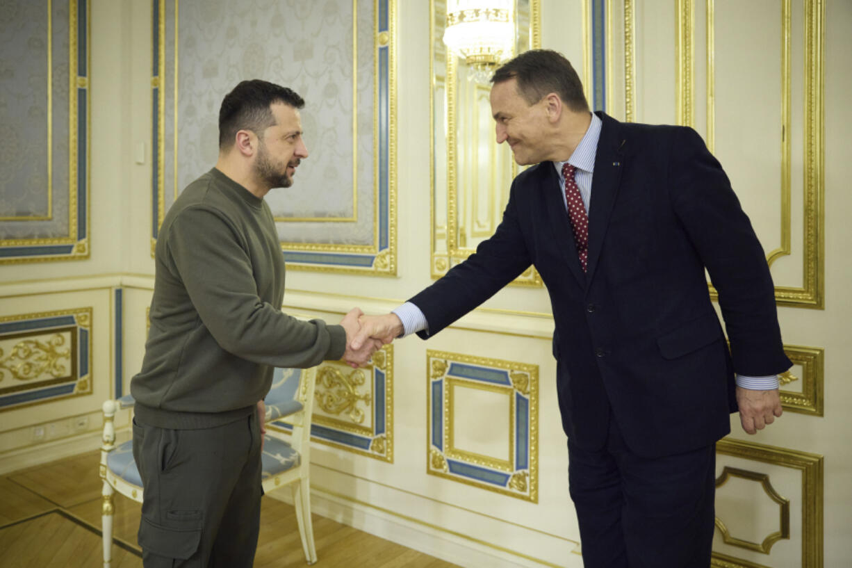 In this photo provided by the Ukrainian Presidential Press Office, Ukrainian President Volodymyr Zelenskyy, left, shakes hands with Poland&rsquo;s Minister of Foreign Affairs, Radek Sikorski, in Kyiv, Ukraine, Friday, Dec. 22, 2023.