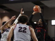 San Diego State guard Reese Waters (14) shoots while pressured by Gonzaga guard Nolan Hickman during the second half of an NCAA college basketball game, Friday, Dec. 29, 2023, in Spokane, Wash. San Diego State won 84-74.