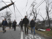 Gov. Bill Lee and first lady Maria Lee, right, walk through the streets ahead of a news conference in Madison, Tenn., Sunday, Dec. 10, 2023, following deadly tornadoes and severe weather over the weekend.