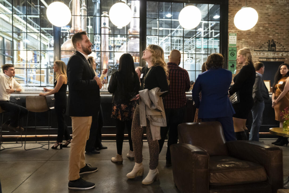 People mingle at a Philadelphia Distilling Daters Mixer Hosted by Date Him Philly, in Philadelphia, Tuesday, Nov. 14, 2023. Some of the most populous urban areas in the United States have an imbalanced sex ratio.