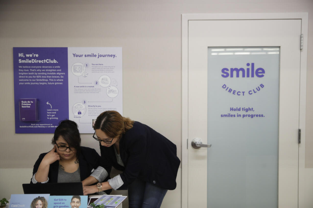 FILE - Dental assistants go over appointments at SmileDirectClub&rsquo;s SmileShop located inside a CVS store April 24, 2019, in Downey, Calif. SmileDirectClub is shutting down, just months after the struggling teeth-straightening company filed for bankruptcy, leaving existing customers in limbo. On Friday, Dec. 8, 2023, the company said it was unable to find a partner willing to bring in enough capital to keep the company afloat, despite a months-long search. (AP Photo/Jae C.