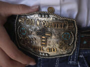 Bull rider Najiah Knight shows her belt buckle after an advertising photo shoot in Fort Worth, Texas, Wednesday, Oct. 4, 2023. Najiah, a high school junior from small-town Oregon, is on a yearslong quest to become the first woman to compete at the top level of the Professional Bull Riders tour.