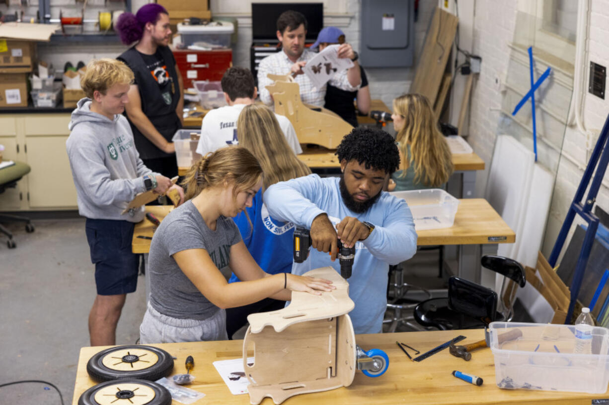 This photo released by Tulane University shows Tulane biomedical engineering students building specially designed mobility chairs for children at the MakerSpace workshop at the university Sunday, Sept. 24, 2023. The students are making the second batch of mobility chairs for toddlers, that will eventually go to pediatric patients at Children&rsquo;s Hospital. Wheelchairs are expensive, and insurance won&rsquo;t cover the cost for children unless the child proves they can operate it independently.