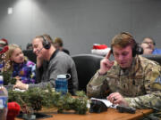 This image provided by the Department of Defense shows volunteers answering phones and emails from children around the globe during the annual NORAD Tracks Santa event on Peterson Air Force Base in Colorado Springs, Colo., Dec. 24, 2022.