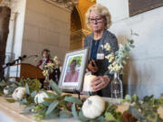 Tracy Wodatch, from Connecticut Association for Healthcare at Home, places a candle next to a photo of Joyce Grayson during the lighting of the candles at a vigil for Grayson at the Connecticut State Capitol&rsquo;s North Lobby on Tuesday, Nov. 28, 2023. , in Hartford, Conn.