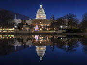 The U.S. Capitol building and the Capitol Christmas Tree are mirrored in the still waters of a reflecting pool early Christmas morning in Washington. (J.