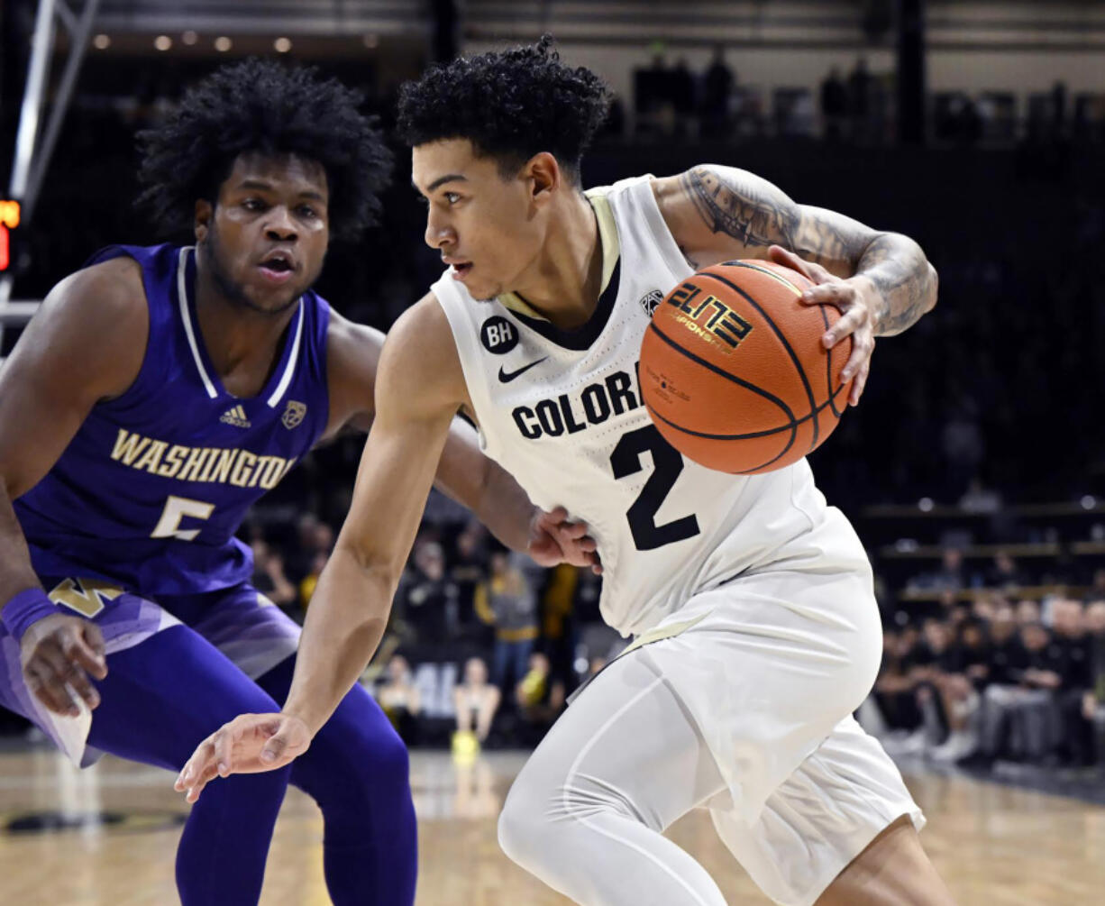 Colorado guard K.J. Simpson, right, drives against Washington guard Sahvir Wheeler during an NCAA college basketball game Friday, Dec. 29, 2023, in Boulder, C/olo.