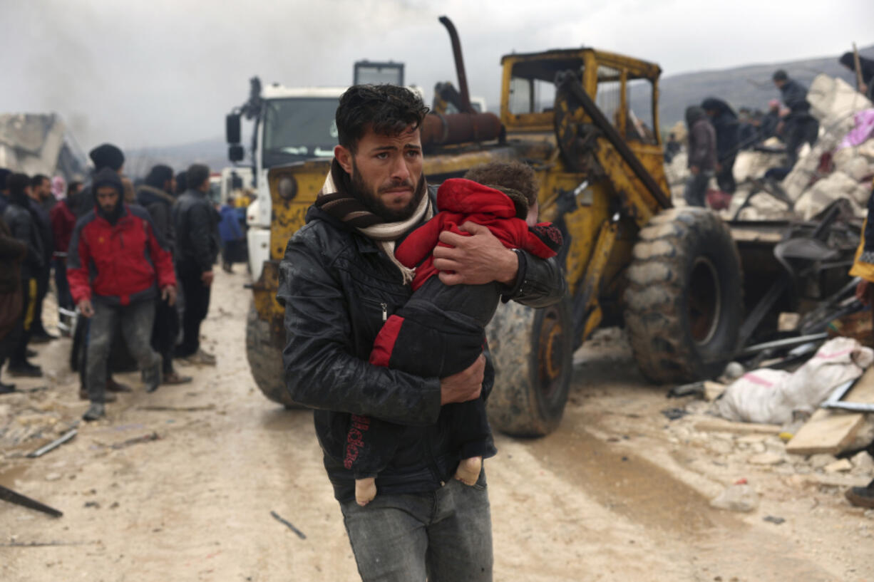 A man carries the body of an earthquake victim Feb.