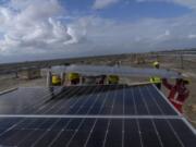 Workers install solar panels Sept. 21 at the under construction Adani Green Energy Limited&rsquo;s Renewable Energy Park in the salt desert of Karim Shahi village, near Khavda, Bhuj district near the India-Pakistan border in the western state of Gujarat, India. Led by new solar power, the world added renewable energy at breakneck speed in 2023, in an effort to turn away from fossil fuels to stave off severe Earth warming and its effects.