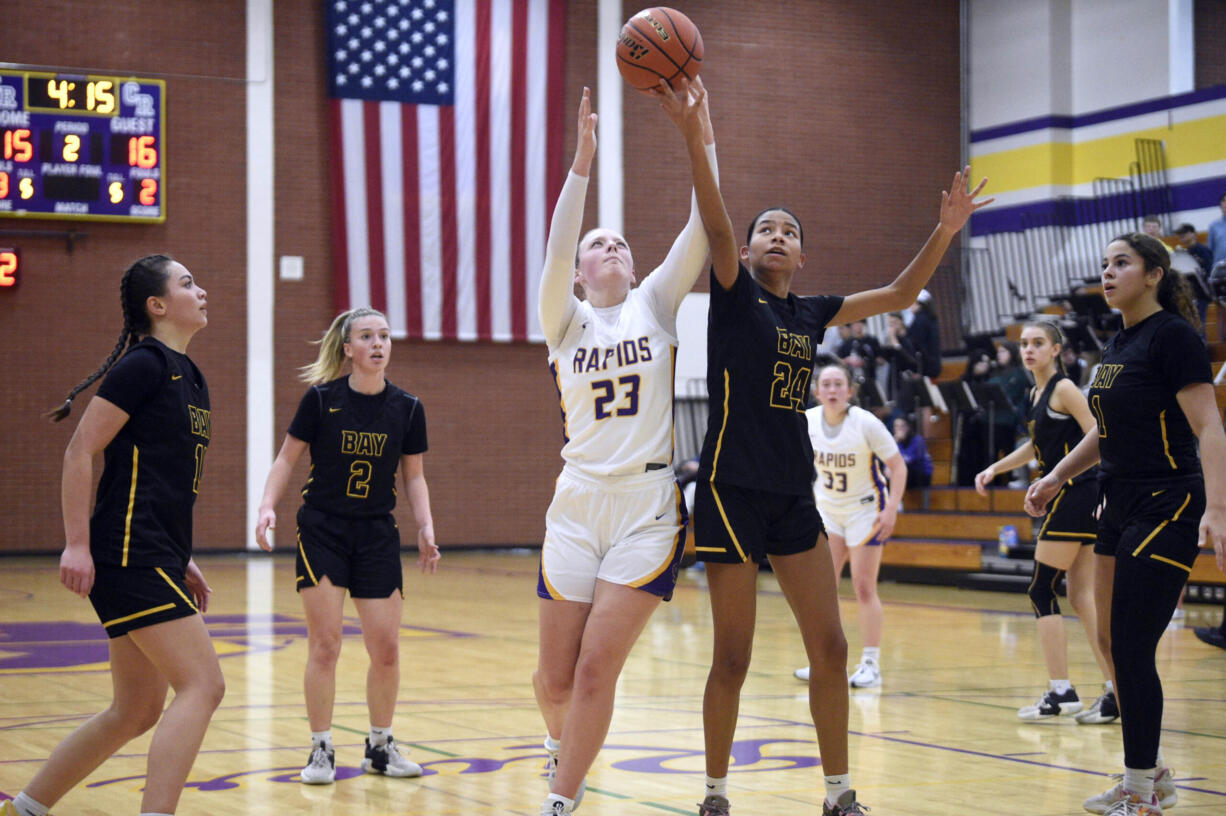 Hudson’s Bay’s Avi Desjarlais (24) and Columbia River’s Kaya Mirtich (23) attempt to grab a loose ball during a 2A Greater St. Helens League girls basketball game on Wednesday, Jan. 3, 2024, at Columbia River High School.