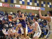 Columbia River’s Ari Richardson looks to throw a pass from the baseline against Ridgefield during a 2A GSHL boys basketball game on Thursday, Jan. 4, 2024, at Ridgefield High School.