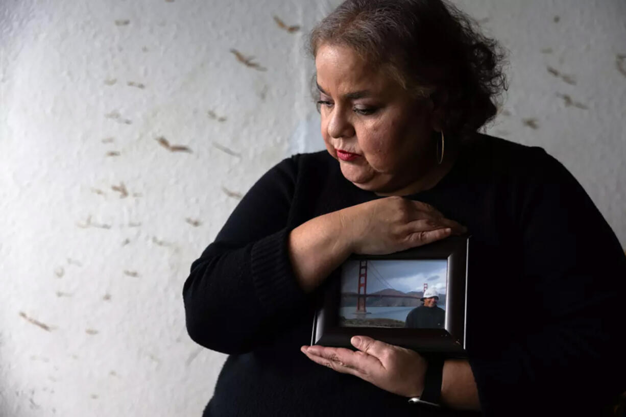 Sandra Mu&Dagger;&plusmn;oz holds a photo of her husband, Luis Acensio Cordero, who was denied his visa, in part, over his tattoos.