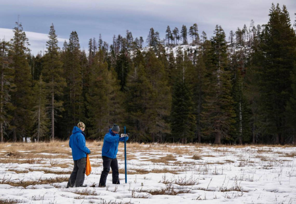 Sean de Guzman, right, snow survey manager at the Department of Water Resources, conducts the first snow survey of the season Jan. 2 with his team at Phillips Station in El Dorado County, Calif.