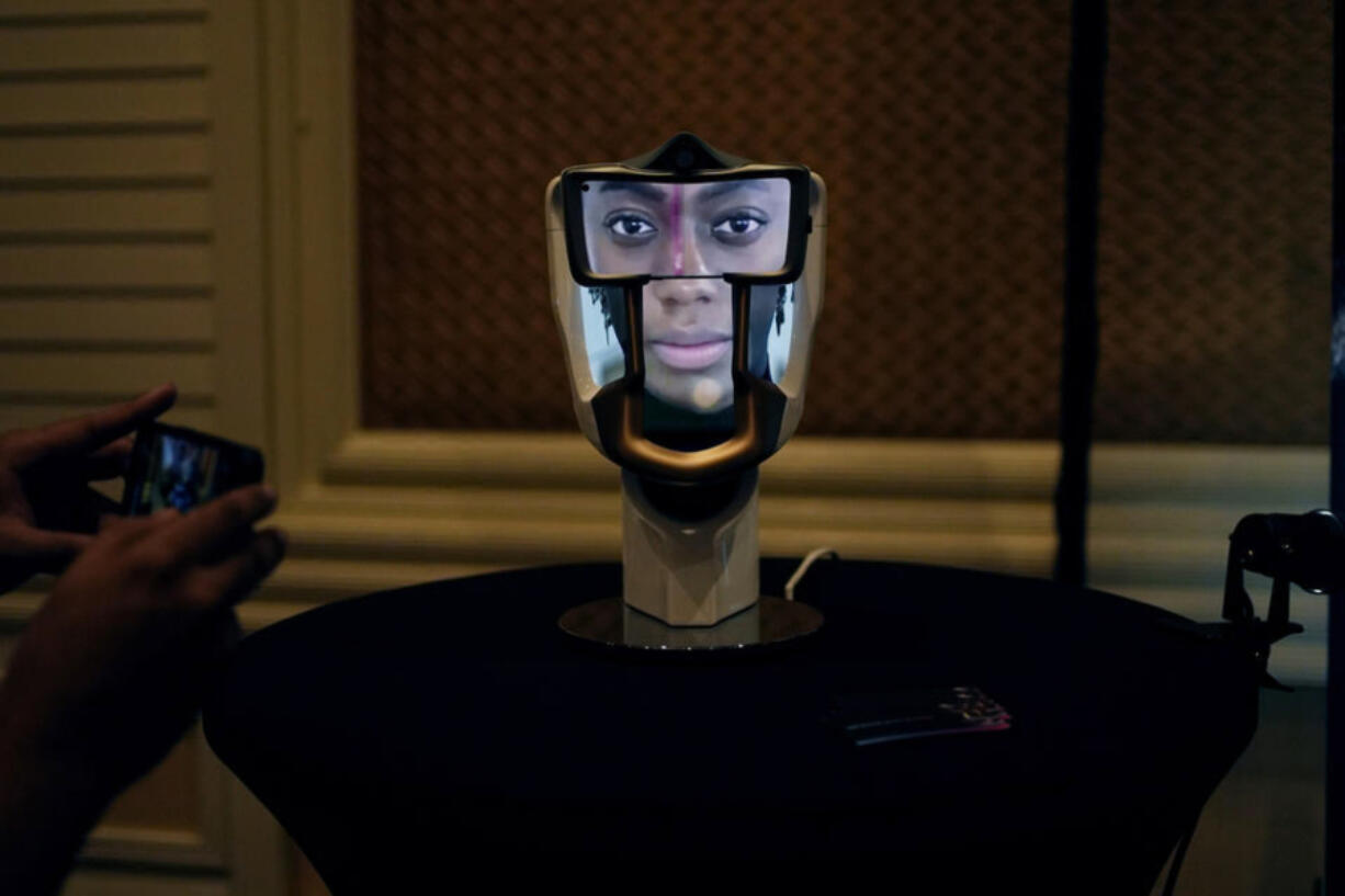 A person takes a picture of a Wehead interactive AI interface at the Wehead booth at Pepcom ahead of the CES tech show Monday, Jan. 8, 2024, in Las Vegas. The device allows for human to AI interaction. Washington legislators will tackle artificial intelligence in the upcoming session.