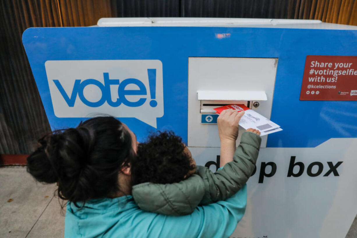 Voters drop off ballots at the White Center Library ballot box on voting day, Tuesday, Nov. 7, 2023.