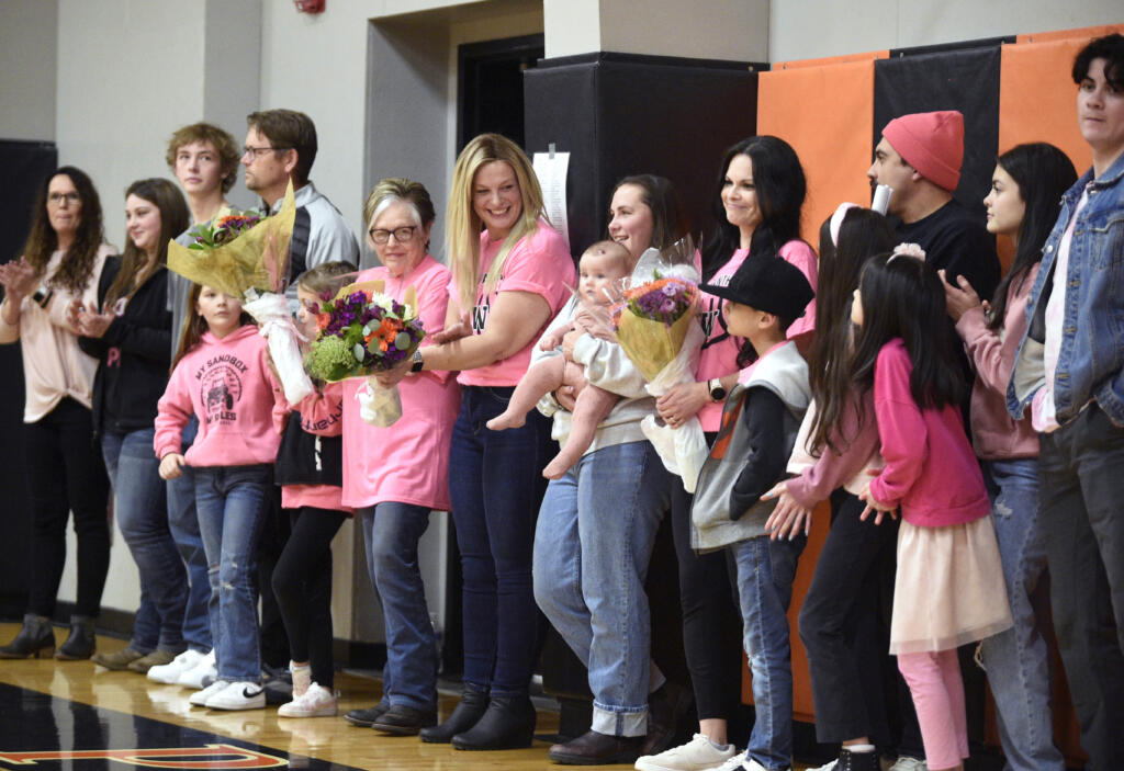 Prior to Washougal’s “Coaches Vs. Cancer” game, the Panthers gave bouquets of flowers and honored three women fighting cancer: Mary Howard, left, Katie Stevens, center, and Melissa Franco, right,  on Thursday, Jan. 25, 2024, at Washougal High School. Stevens, a former Washougal High student and girls basketball player, was diagnosed with breast cancer in 2022. Howard and Franco, both Washougal residents, are cancer survivors.