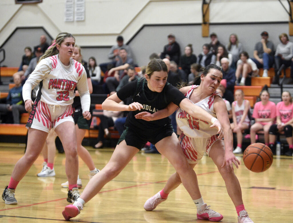 Woodland’s Kennedy Bockert, center, and Washougal’s Jenna Klopman, right, go after a loose ball during the Panthers’ “Coaches vs. Cancer” game against Woodland on Thursday, Jan. 25, 2024, at Washougal High School. Many Woodland players wore pink shoes and ribbons to show their support for the event.