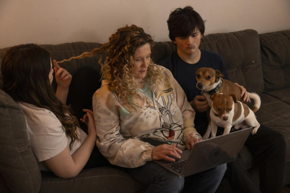 Amy Roark, center, spends time with two of her children, GracieLynn Rich (left) and Kayden Wake (right) at her home in Vancouver, Wash. on Sunday, Jan. 21, 2024. Roark was on TANF for several years during which time the state intercepted thousands of dollars of child support payments meant for her children. Now she&Ccedil;&fnof;&Ugrave;s off TANF but still struggling after the loss of that money.