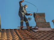 A chimney sweep will use various tools to clear out debris.