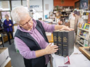 Pepper Parker, a 19-year employee of Vintage Books, shows off a 1928 set of &ldquo;History of the Columbia River Valley: from The Dalles to the Sea&rdquo; at the shop in Vancouver.